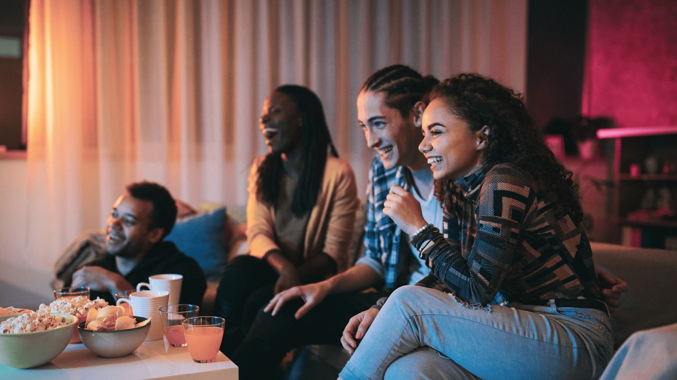 Group of friends eating Snacks to Stock for a Big Night In TV