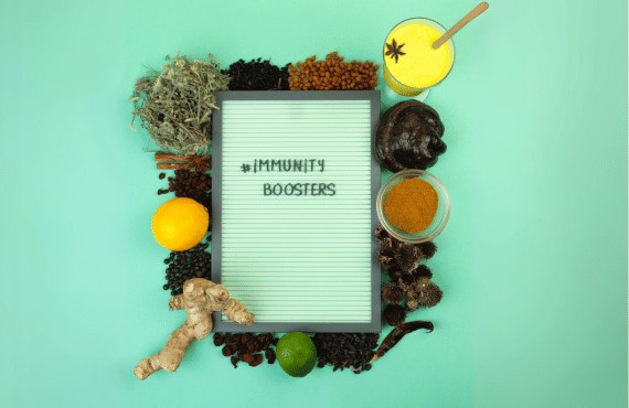 Immunity-Boosting Drinks and Snacks Blog Image 1- immunity Boosting Ingredients surrounding a white board with the words immunity boosters written on it
