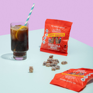 A packet of Savvy Sweets next to a glass of cola