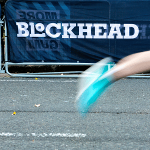 A Blockhead Gum banner behind a blurred running trainer going passed